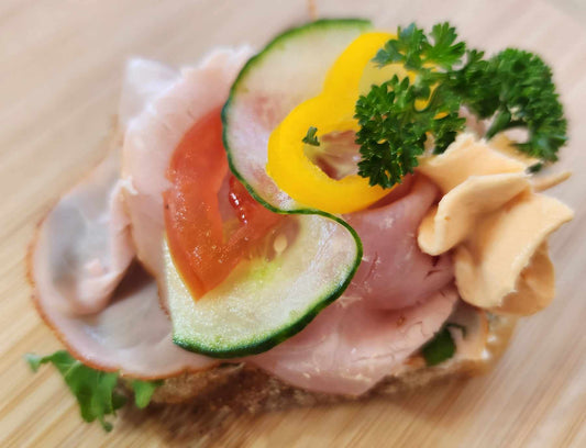 Ham sandwich: sourdough bread, cream cheese base, smoked ham, vegetable garnish. Sold in quantities of 8 or 20 sandwiches. Mix and match in a box!